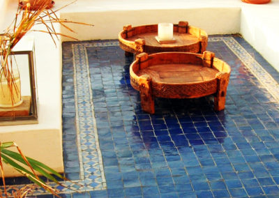 Terrasse en zellige bleu, soutenue par une frise en Bejmat dans une ambiance marocaine