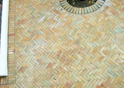 Terrasse en Bejmat naturel de différents nuances de coloris, pose en chevron.