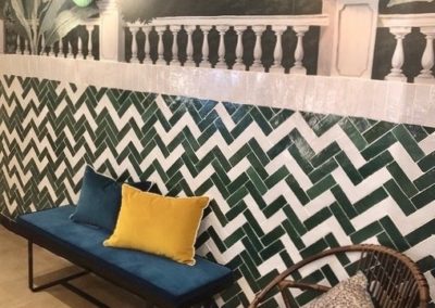 Habillage de mur en Bejmats blancs nacrés et verts émeraude posés en chevron aléatoire