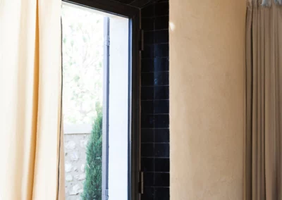 Encadrement de fenêtre de chambre en carreaux noirs de 10x10 cm sur un mur blanc