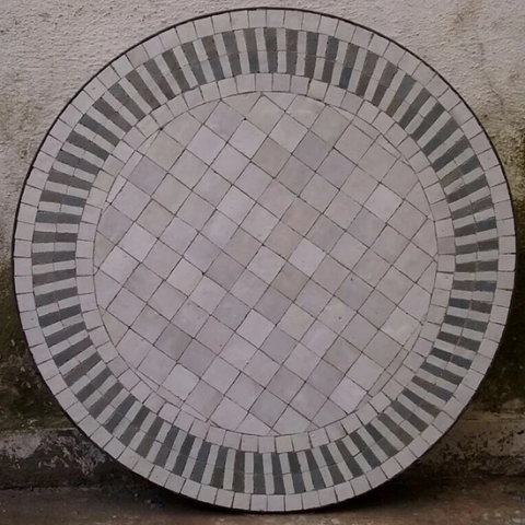 Création artisanale d'un plateau rond pour une table en zellige et fer forgé, motif rayé de couleur blanc et gris perle