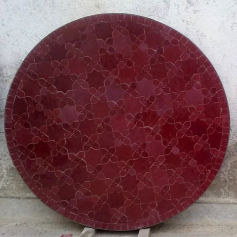 Plateau de table unicolore en zellige rouge avec un motif en fleur de matécha. diamètre 90cm