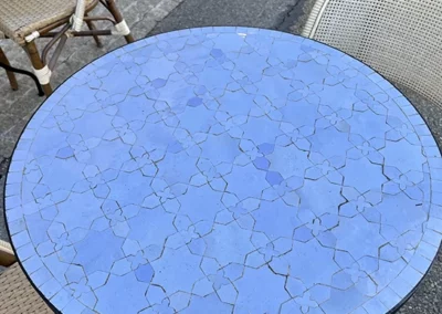 Table bistro, haute et ronde, en zellige, couleur bleu ciel et motif fleur de matécha