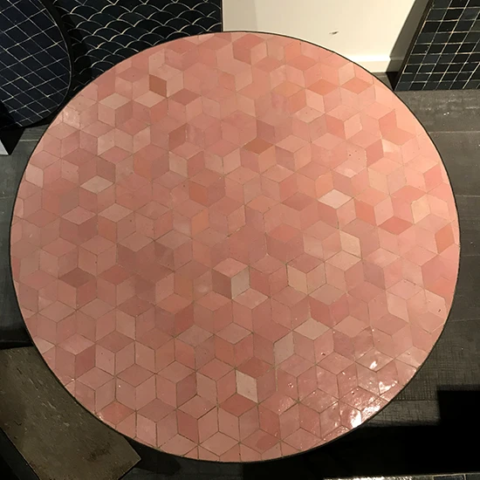 Table ronde en zellige rose et saumon, motif cube, exposée dans le showroom de Art et Sud Déco Paris
