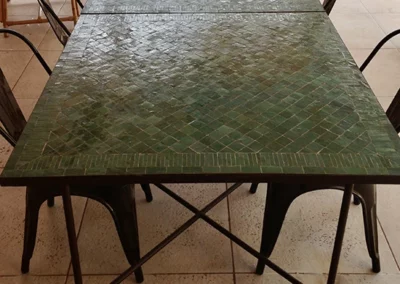 tables de repas carrées en zellige rayé vert anglais et piètements croisés en fer forgé à la main